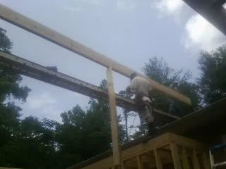 Carpenter setting a ridge beam over a new addition frame — Ice Dam Removal by Roofing Brothers in Egg Harbor Township