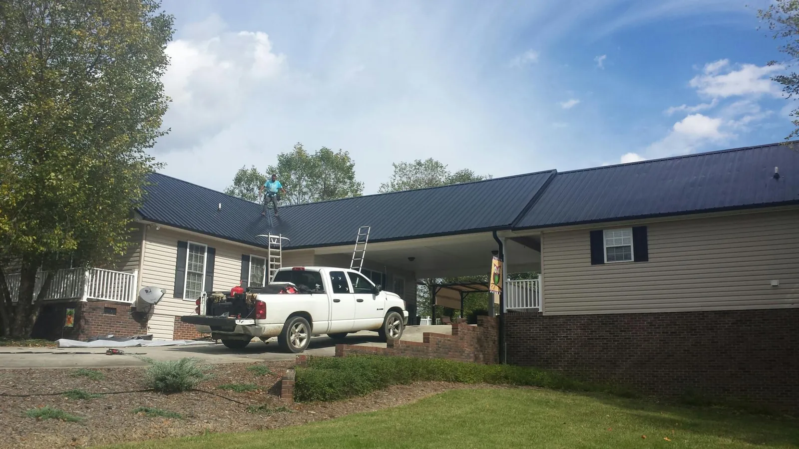 Black metal roof over a home and attached breezeway with ladders set in Egg Harbor Township